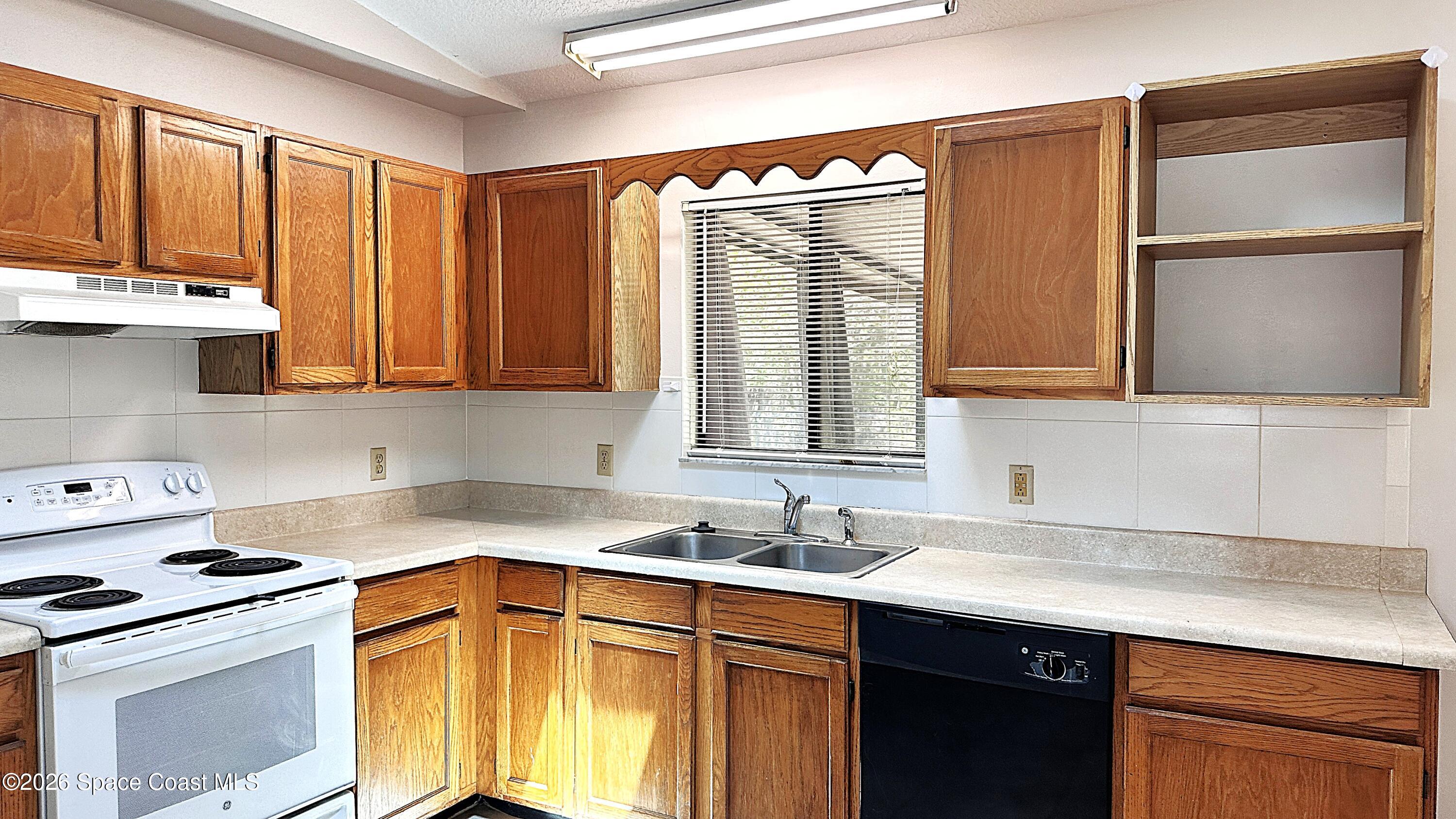 931 Commerce Road Southeast Palm Bay, FL 32909 - Photo 6 of 19 a kitchen with stainless steel appliances a sink stove and cabinets