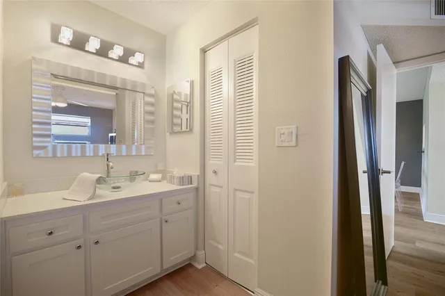 a bathroom with a toilet a sink a mirror a shower a vanity and window