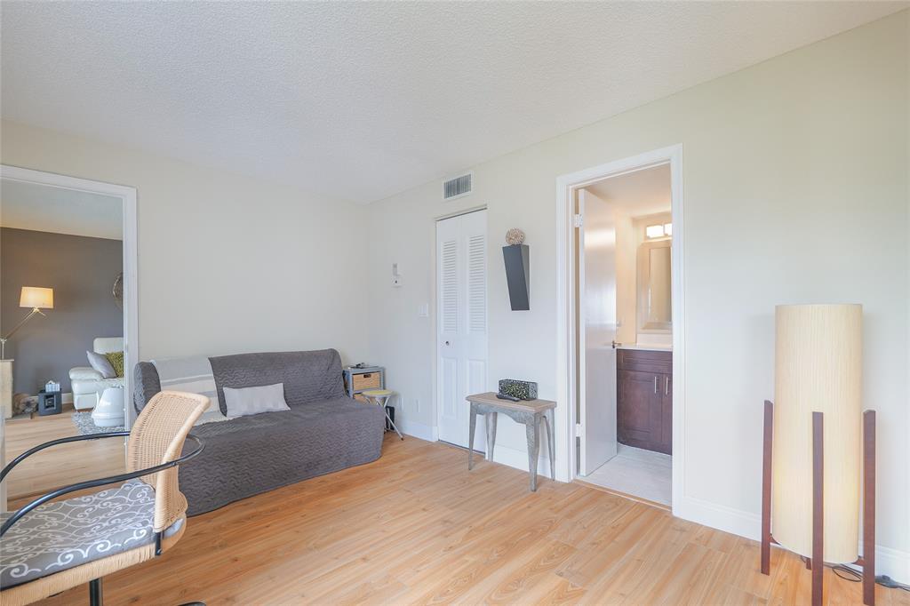 3531 Inverrary Drive, Unit 407 Lauderhill, FL 33319 - Photo 23 of 59 a bedroom with a bed and wooden floor