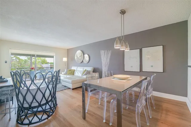 a living room with furniture a chandelier and a dining room