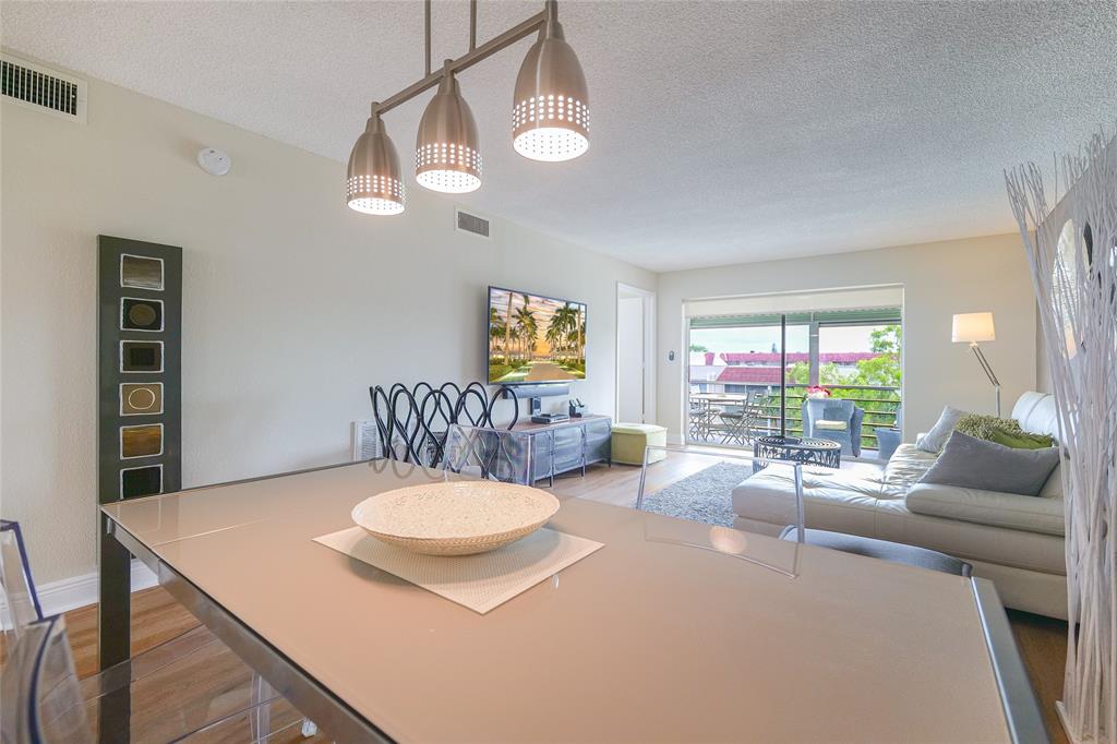 3531 Inverrary Drive, Unit 407 Lauderhill, FL 33319 - Photo 7 of 59 a living room with furniture a chandelier and a dining room