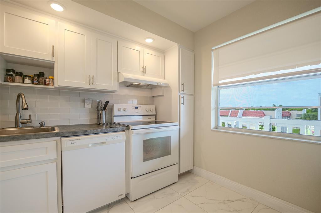 3531 Inverrary Drive, Unit 407 Lauderhill, FL 33319 - Photo 10 of 59 a kitchen with stainless steel appliances granite countertop white cabinets and a window