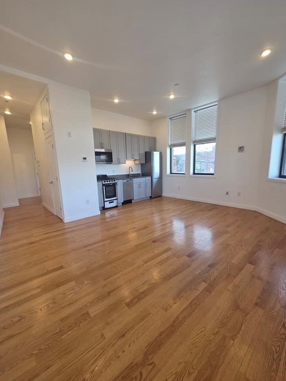 64 Market Street, Unit 303 Lynn, MA 01901 - Photo 2 of 12 an empty room with wooden floor and windows