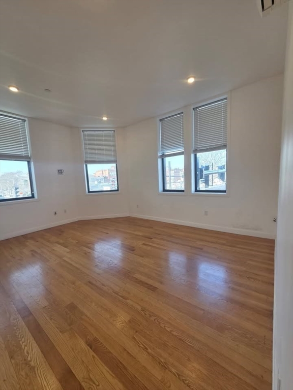 64 Market Street, Unit 303 Lynn, MA 01901 - Photo 3 of 12 a view of an empty room with wooden floor and window