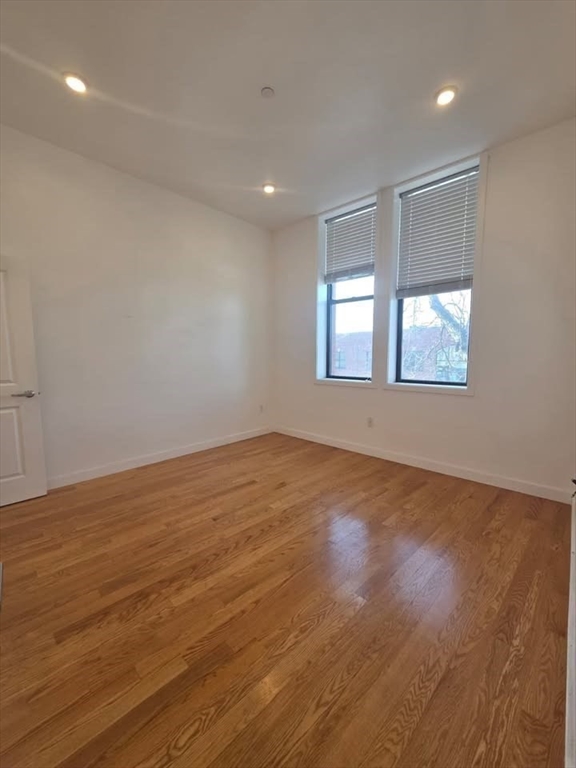 64 Market Street, Unit 303 Lynn, MA 01901 - Photo 5 of 12 an empty room with wooden floor and windows