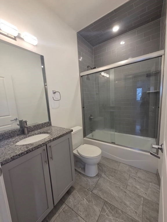 64 Market Street, Unit 303 Lynn, MA 01901 - Photo 7 of 12 a bathroom with a granite countertop sink toilet and shower