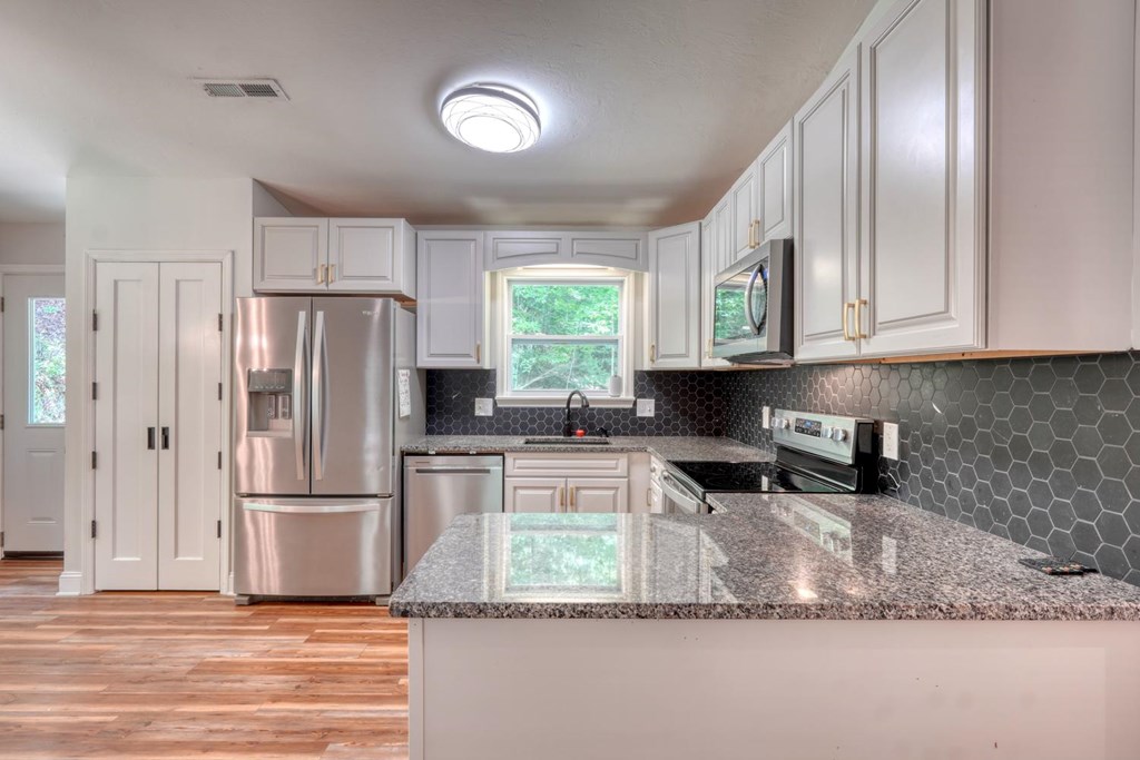 45 Mountain Stream Road Murphy, NC 28906 - Photo 13 of 33 a kitchen with stainless steel appliances granite countertop a refrigerator sink and cabinets