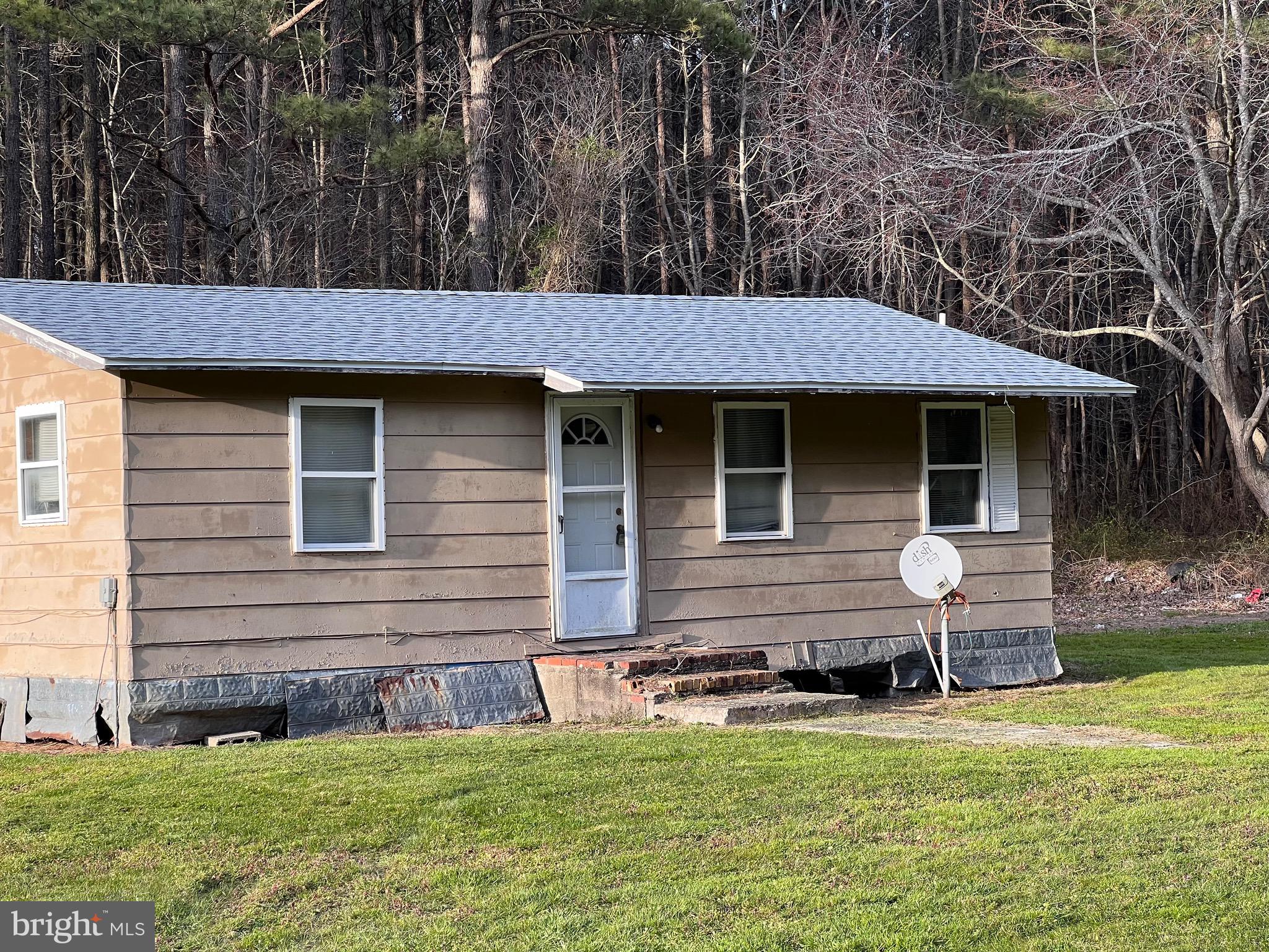 28098 Black Road Princess Anne, MD 21853 - Photo 1 of 5 a front view of a house with a garden and patio