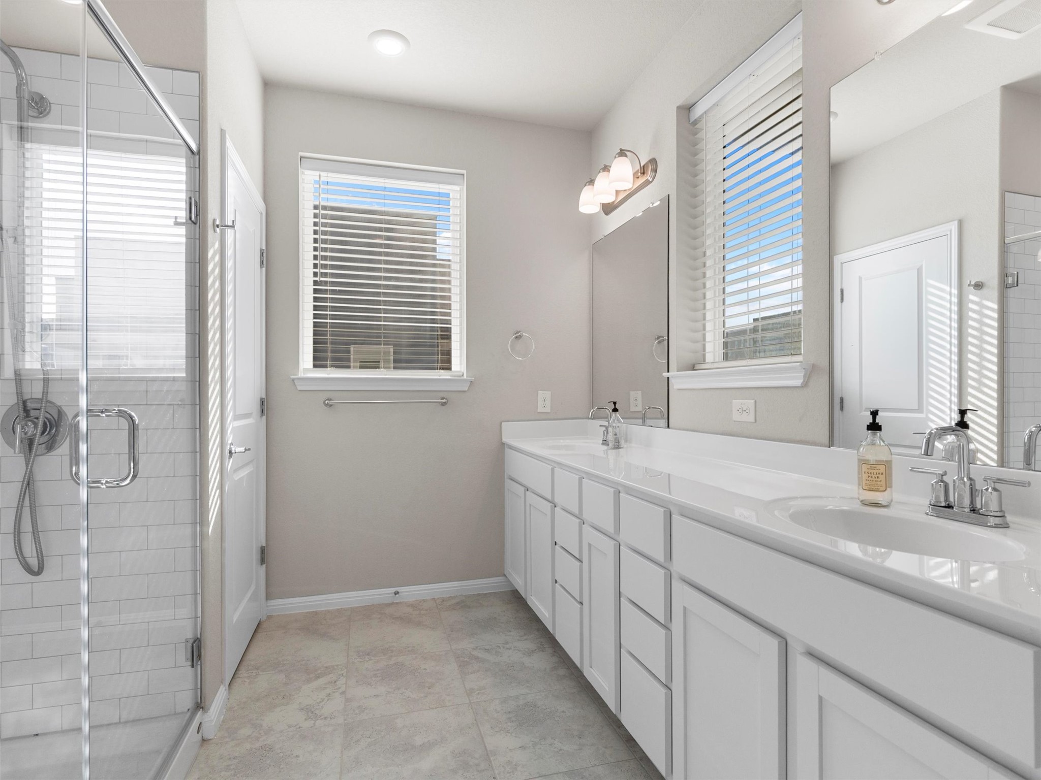 9015 Cattle Baron Path, Unit 2001 Austin, TX 78747 - Photo 16 of 32 a bathroom with double sink and a shower