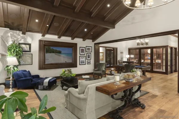 a living room with furniture pool table and a chandelier