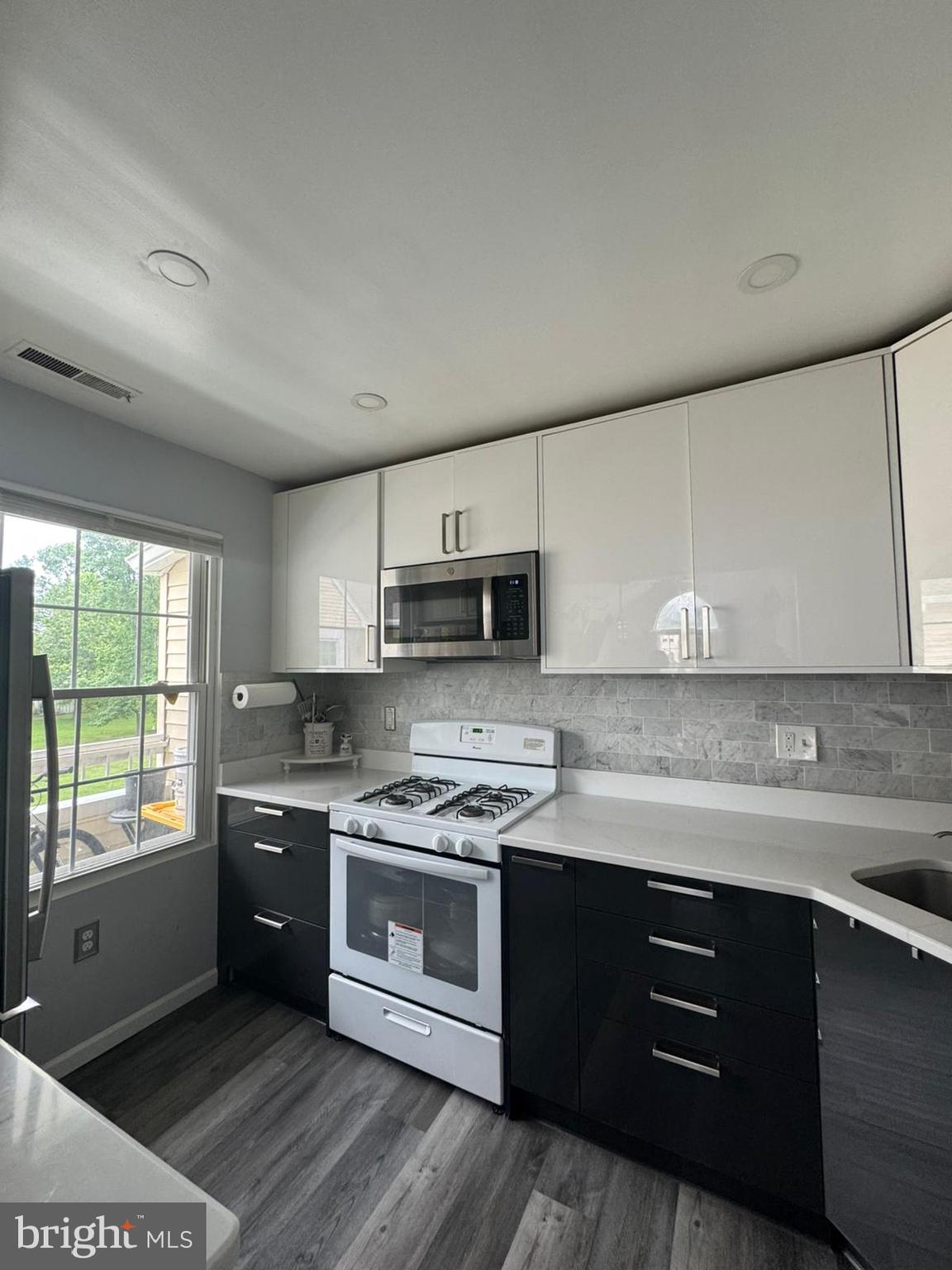 23 Powell Court Hightstown, NJ 08520 - Photo 13 of 31 a kitchen with stainless steel appliances granite countertop a sink a stove a refrigerator cabinets and a window