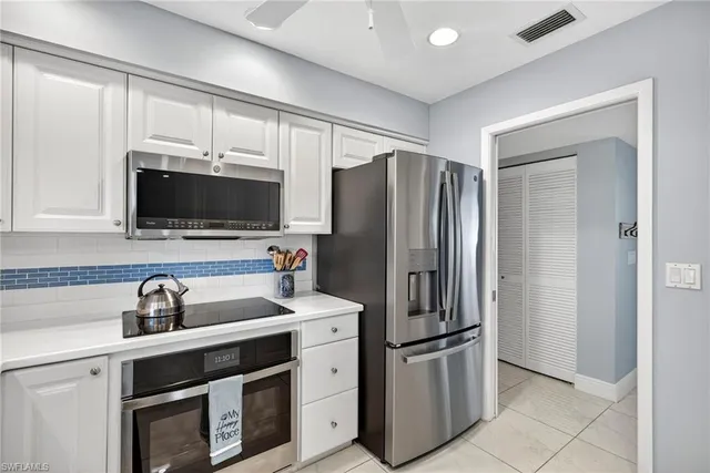 a kitchen with stainless steel appliances a refrigerator sink and microwave