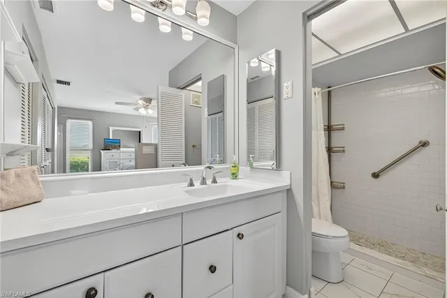 a bathroom with a double vanity sink toilet and shower