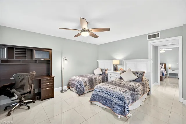 a bedroom with two beds and a chair