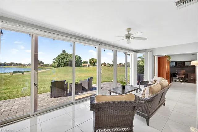 a living room with furniture and floor to ceiling windows