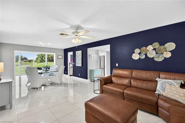 a living room with furniture chandelier and a large window