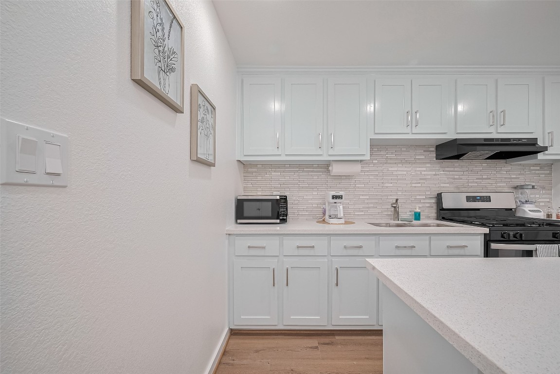 6725 Avenue K Houston, TX 77011 - Photo 9 of 23 a kitchen with white cabinets stainless steel appliances and sink