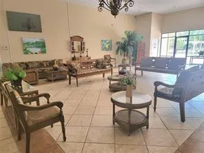 a living room with furniture a chandelier and a flat screen tv