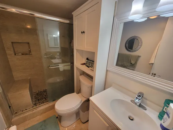 a bathroom with a sink a toilet and shower