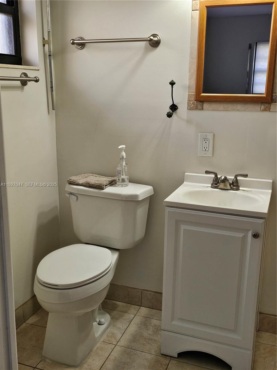 3202 Pierce Street, Unit 3202 Hollywood, FL 33021 - Photo 11 of 12 a bathroom with a toilet sink and mirror