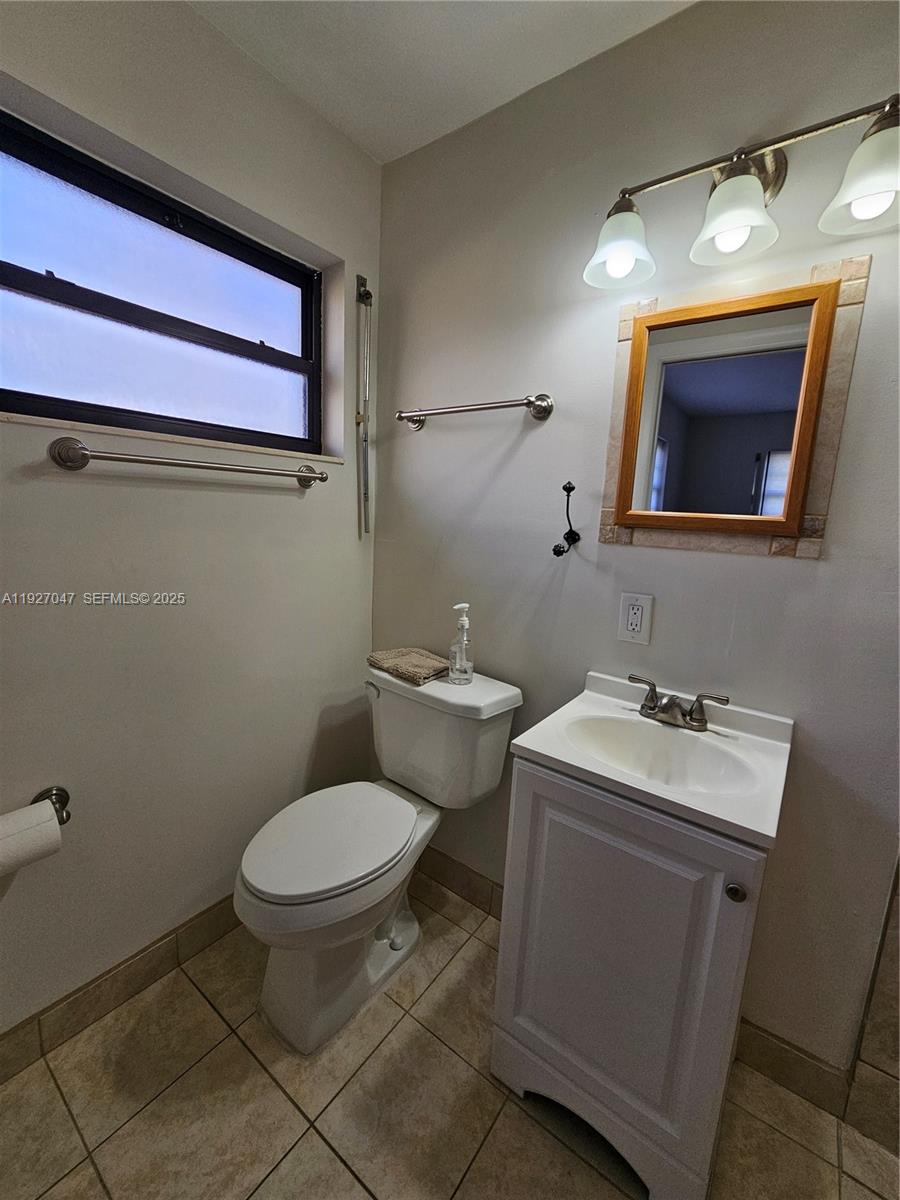 3202 Pierce Street, Unit 3202 Hollywood, FL 33021 - Photo 10 of 12 a bathroom with a toilet sink and mirror