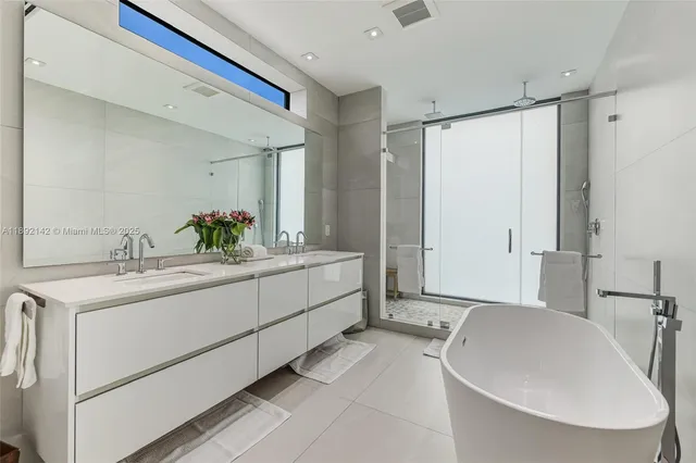 a bathroom with a double vanity sink mirror and shower