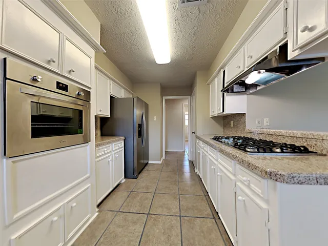 a kitchen with stainless steel appliances granite countertop a stove and a refrigerator