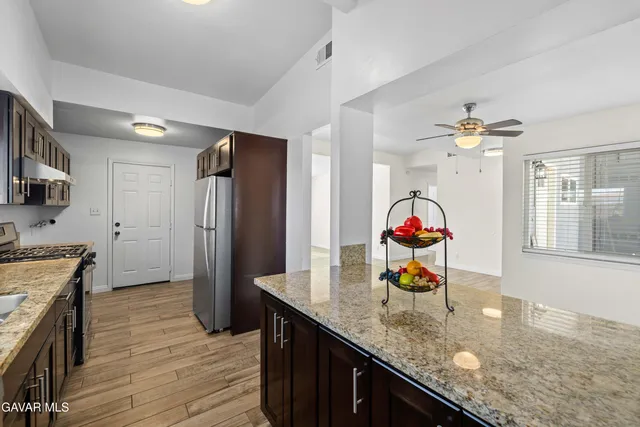 a kitchen with stainless steel appliances granite countertop a refrigerator and a stove
