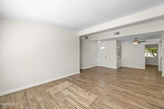 a view of empty room with wooden floor