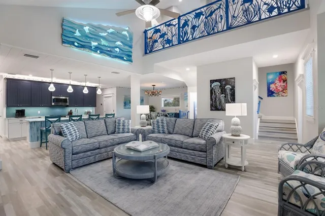 a kitchen with granite countertop a stove a sink a dining table and chairs with wooden floor