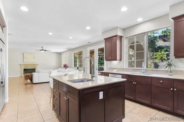 a kitchen with granite countertop a sink and white cabinets