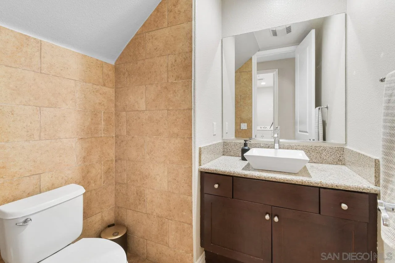 2957 Ranch Gate Road Chula Vista, CA 91914 - Photo 22 of 72 a bathroom with a granite countertop sink toilet and mirror