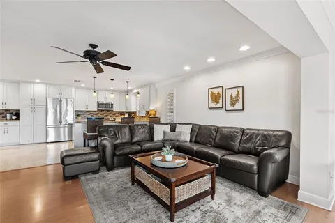 a living room with furniture kitchen view and a chandelier