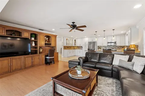a living room with furniture kitchen view and a flat screen tv