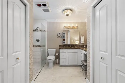 a bathroom with a granite countertop sink mirror and a toilet