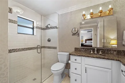 a bathroom with a granite countertop sink toilet and shower