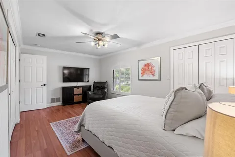 a spacious bedroom with a bed and a flat screen tv
