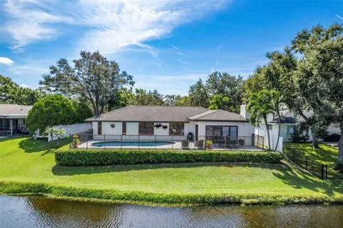 a front view of a house with a garden and lake view