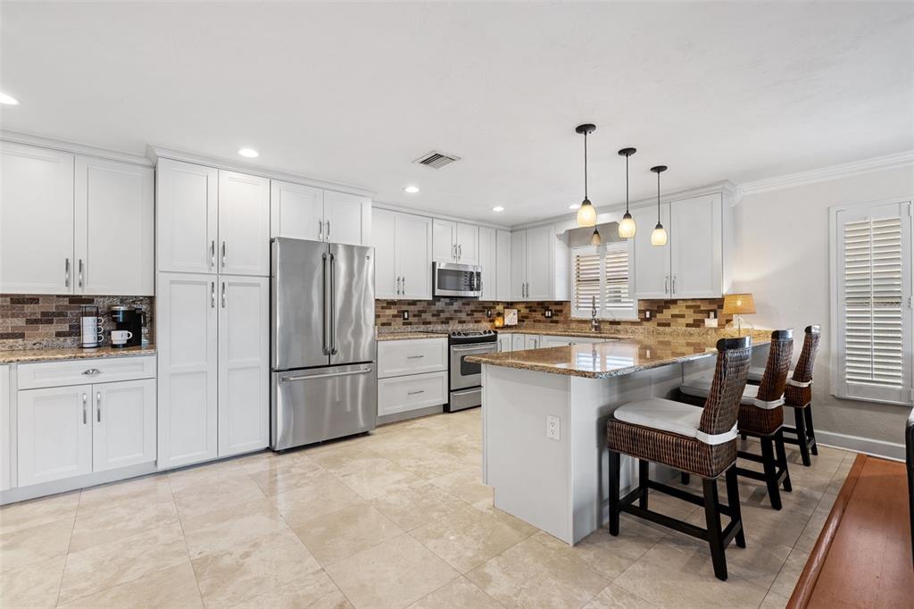 657 Riviera Bay Drive Northeast St. Petersburg, FL 33702 - Photo 8 of 50 a kitchen with white cabinets and stainless steel appliances