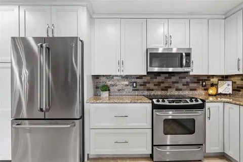a kitchen with cabinets stainless steel appliances and a sink