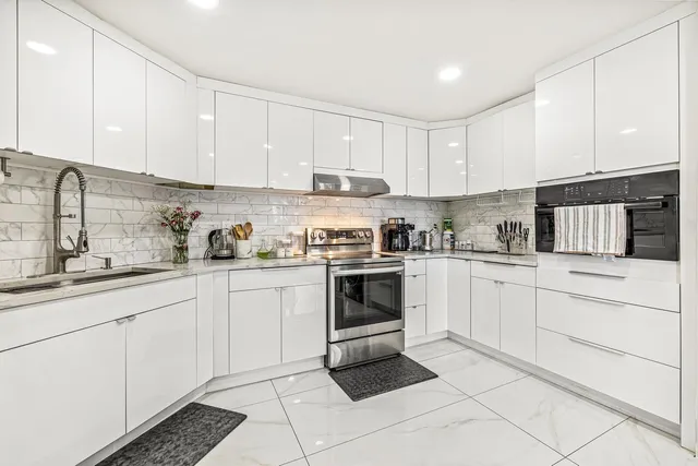 a kitchen with cabinets stainless steel appliances and a sink
