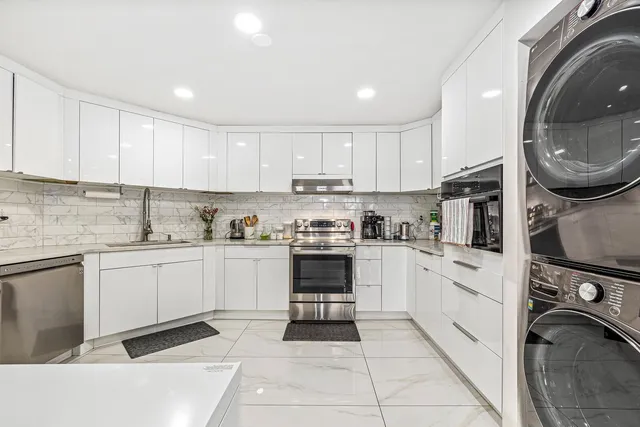 a kitchen with stainless steel appliances granite countertop a stove sink and cabinets