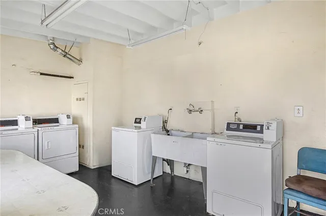 a room with a sink a stove and white cabinets