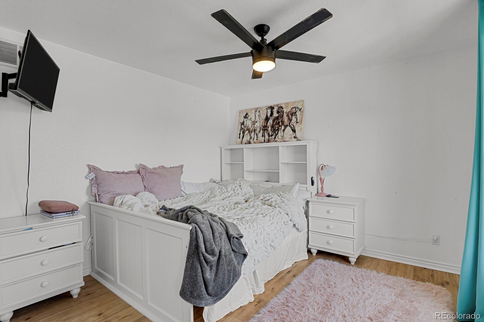 897 East Rim Road Franktown, CO 80116 - Photo 15 of 32 a bedroom with a bed and a flat screen tv