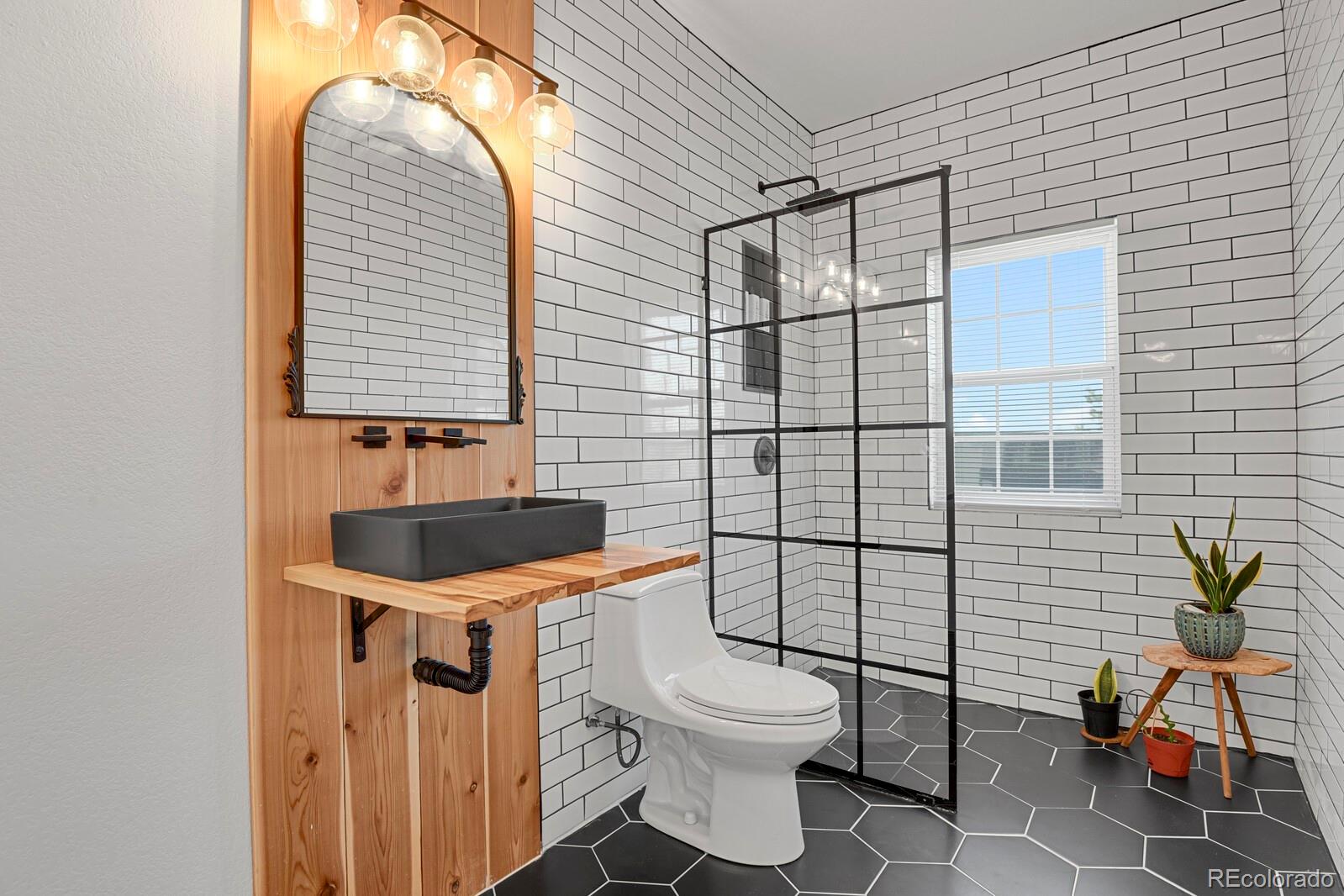 897 East Rim Road Franktown, CO 80116 - Photo 19 of 32 a bathroom with a toilet sink and mirror