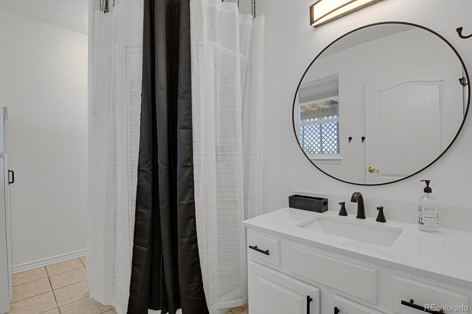 897 East Rim Road Franktown, CO 80116 - Photo 22 of 32 a bathroom with a sink and a mirror