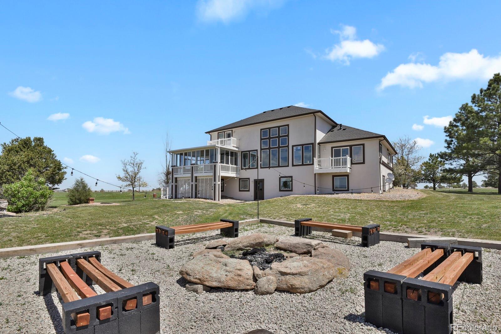 897 East Rim Road Franktown, CO 80116 - Photo 24 of 32 a view of a backyard with couches plants and large trees