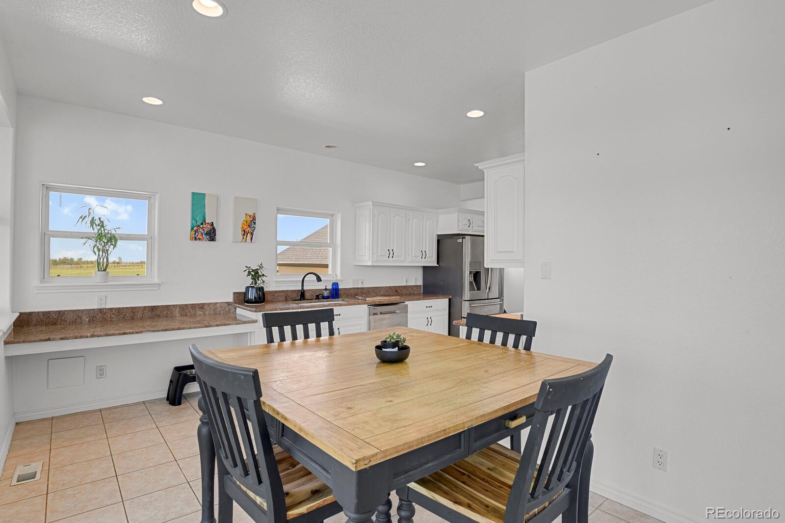 897 East Rim Road Franktown, CO 80116 - Photo 10 of 32 a kitchen with a dining table chairs and refrigerator