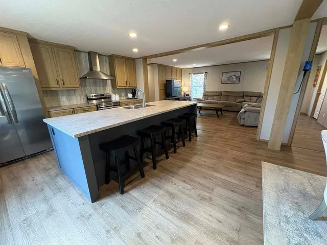 a large kitchen with stainless steel appliances a large counter top