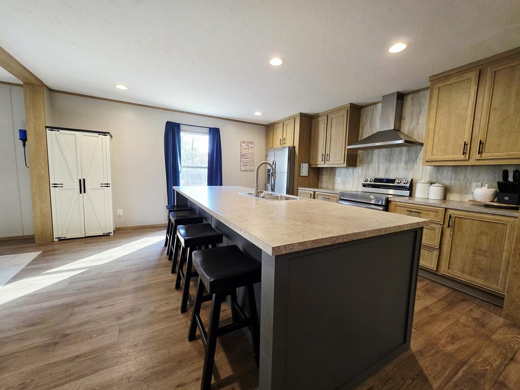 103 Appaloosa Road Buena Vista, GA 31803 - Photo 5 of 24 a kitchen with kitchen island granite countertop wooden floors and refrigerator